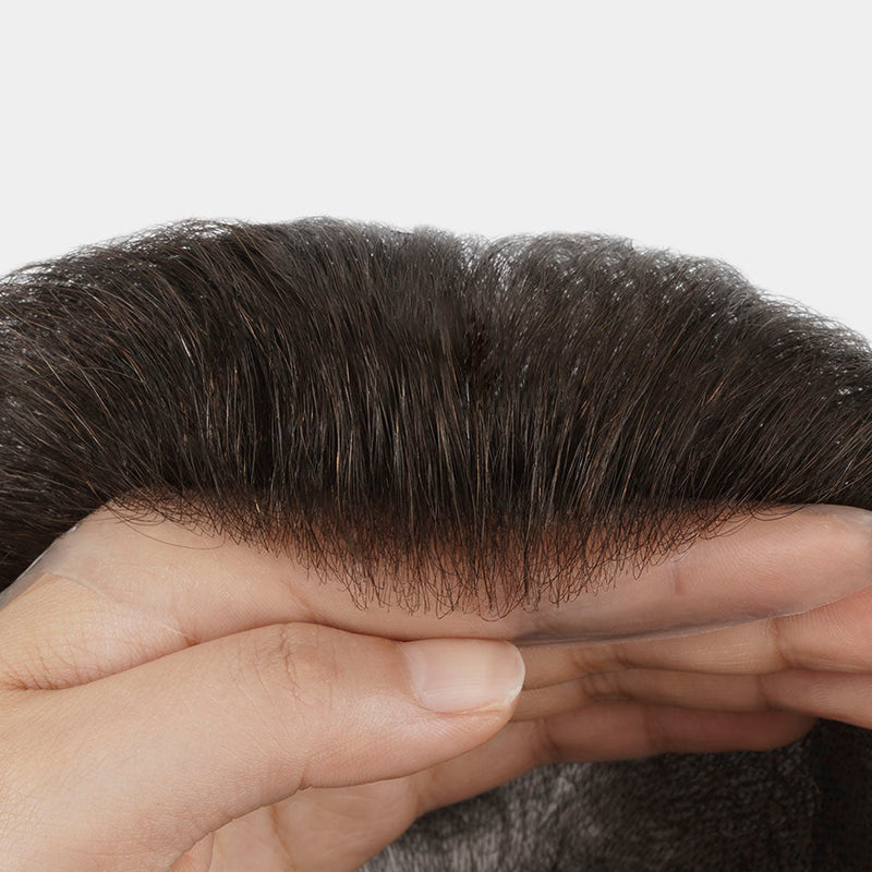 Thin skin men's hair system held in hand, showing the hairline