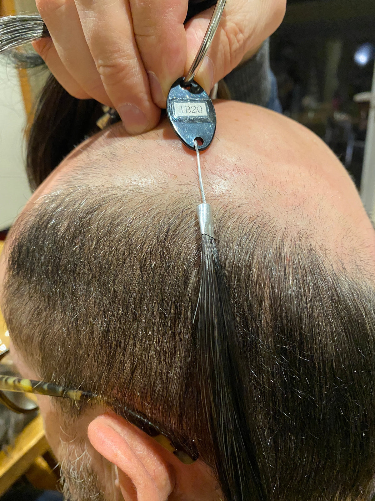 Colour ring held against the hair to match the exact shade at a ReGain matching appointment