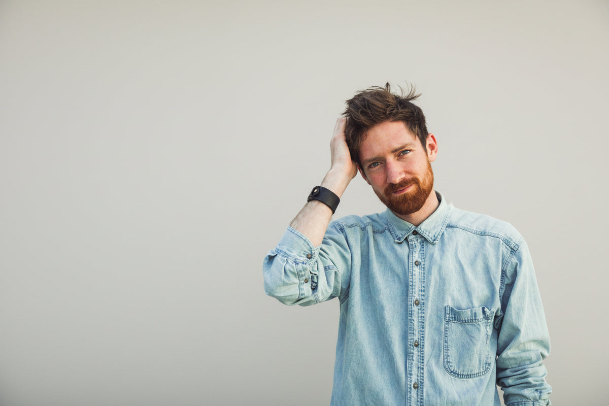 Mann, der sich mit der Hand durchs Haar fährt